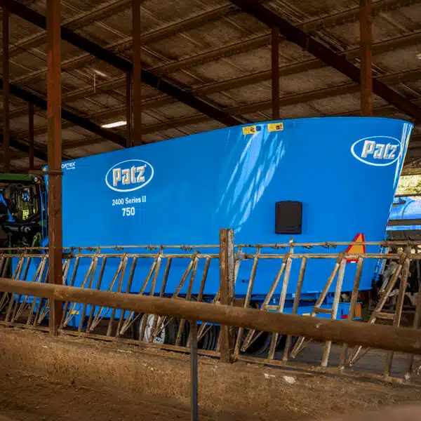 A Patz feed mixer wagon inside a dairy barn.