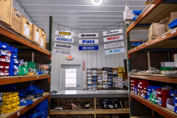 Schmidt Building Parts Department with brand signs hanging from ceiling.
